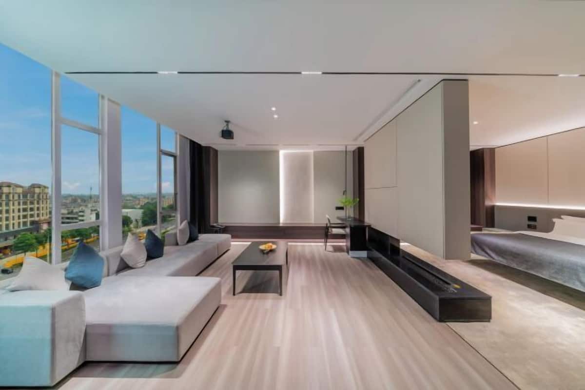 Una sala de estar moderna con un ventanal grande, un sofá, una mesa de centro y un televisor.