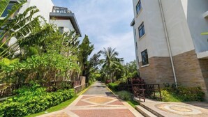 A pathway flanked by lush greenery and modern buildings with a geometric patterned walkway. - Sanya Xiyue Luxury Villa (Yalong Bay Forest Park Branch) (Sanya)