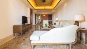 A spacious living area with a modern sofa, a television on a wooden console, and a lamp on a side table. - Sanya Xiyue Luxury Villa (Yalong Bay Forest Park Branch) (Sanya)