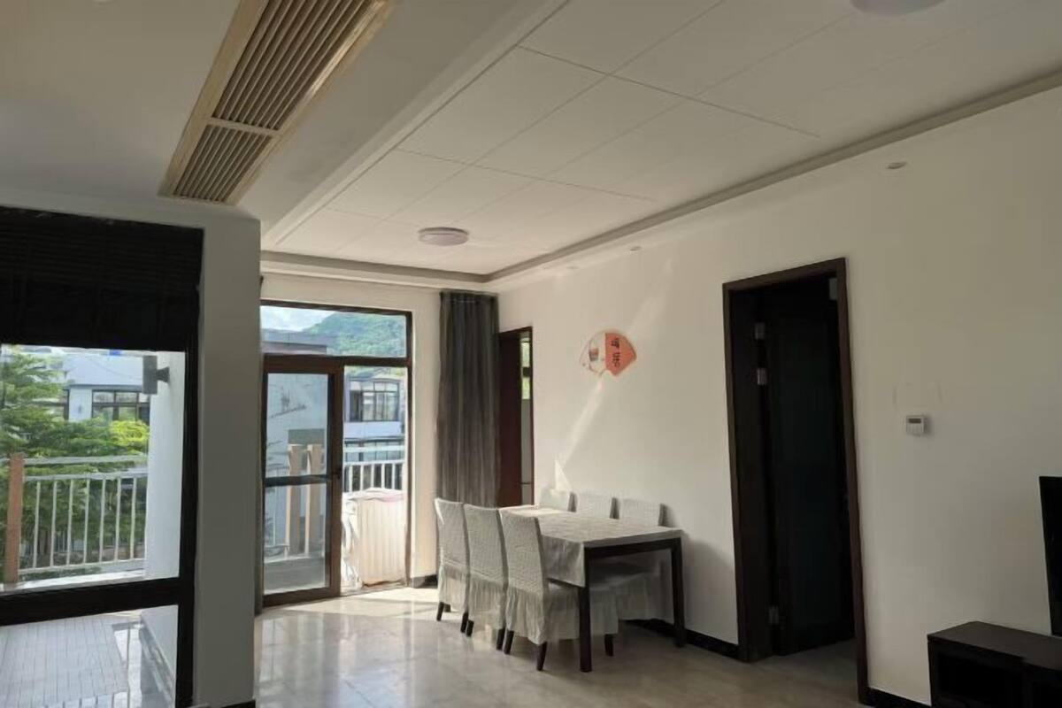 Une pièce spacieuse comprenant un coin repas, de grandes fenêtres et un balcon.