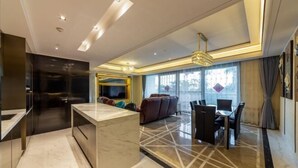 A modern living room with a marble floor, a central island, a dining area with chairs, and a large window with curtains. - Sanya Xiyue Luxury Villa (Yalong Bay Forest Park Branch) (Sanya)