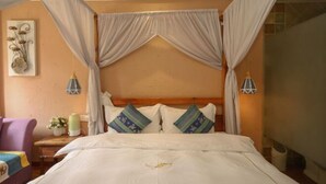 Un dormitorio con cama a dosel, cabecera de madera y dos lámparas fijadas a la pared.