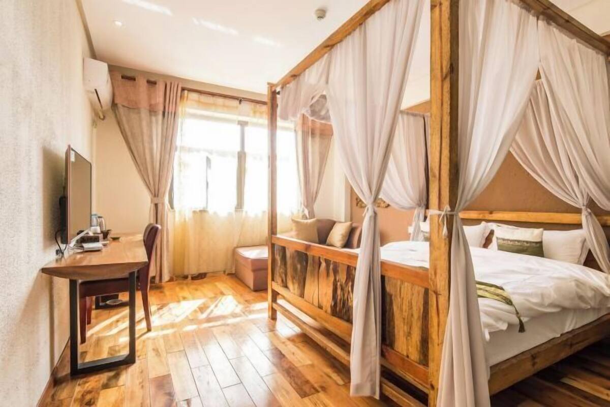 A room with a wooden bed, a desk, and a chair.