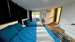 Une chambre avec deux lits, un escalier et une vue sur l’extérieur.
