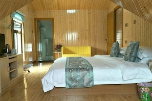 Una habitación con paneles de madera, una cama, un escritorio y una silla.
