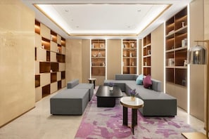 A modern hotel lobby with a seating area, bookshelves, and a reception desk. - 7 Days Inn Selected (Beijing South Station Yongdingmen Subway Station) (Beijing)