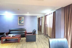 A hotel room with a sofa, a small table, a chair, and a mirror. - Dafuhao Hotel (Yichun Runda International Yuanzhou Gulou Square Branch) (Yichun)