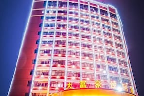 A tall hotel building with multiple floors and illuminated windows. - Dafuhao Hotel (Yichun Runda International Yuanzhou Gulou Square Branch) (Yichun)