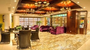 A lobby with a patterned carpet, sofas, a dining area, and a bookshelf. - Dafuhao Hotel (Yichun Runda International Yuanzhou Gulou Square Branch) (Yichun)