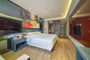 A modern hotel room with a large bed, a desk, a TV, and a painting on the wall. - Dafuhao Hotel (Yichun Runda International Yuanzhou Gulou Square Branch) (Yichun)