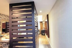 Un pasillo de diseño moderno con un separador de madera con listones horizontales.