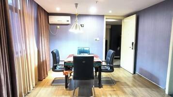 Una sala de conferencias con una mesa, sillas y una lámpara en el techo.