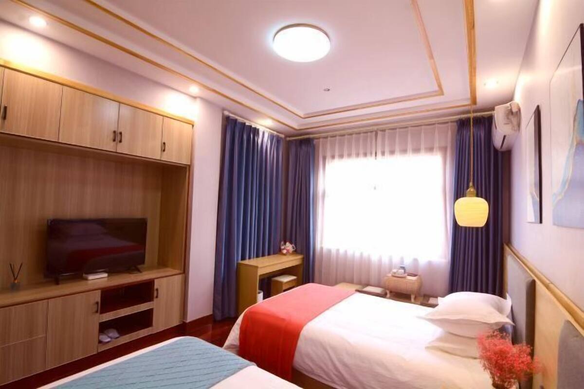 Een hotelkamer met een bed, een televisie, een bureau en een kledingkast.