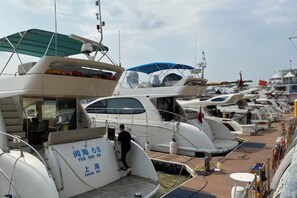 A marina with multiple yachts docked, some with covered areas and visible decks. - Shanghai Jinli S Hotel (Lujiazui Bund Branch) (Shanghai)