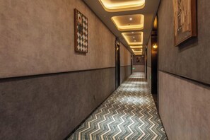 A corridor with patterned flooring, recessed lighting, and framed artwork on the walls. - Shanghai Jinli S Hotel (Lujiazui Bund Branch) (Shanghai)