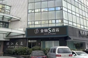A hotel building with a sign for Jinli S Hotel. There are cars parked in front. - Shanghai Jinli S Hotel (Lujiazui Bund Branch) (Shanghai)