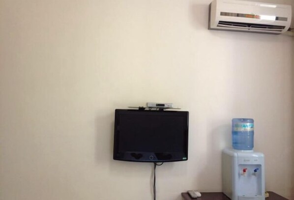 A wall-mounted television, a water dispenser, and an air conditioner. - Industry Hotel (Zhaoyuan)