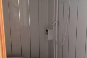 Ein Badezimmer mit Duschkabine, Handtuchhalter und Toilette.
