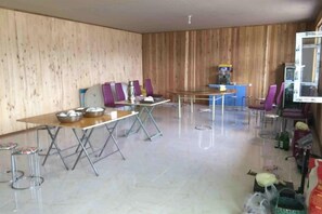A room with a long dining table, several chairs, a small kitchen area, and a television. - Dayong Travel Home (Erguna Shiweizhen Linjiang Branch) (Ergun)