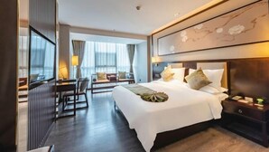 A hotel room with a large bed, bedside tables, a desk, and a chair. - Huawen International Hotel (Shijiazhuang)