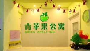 A sign for the Green Apple Inn with a green apple logo and Chinese characters. - Lianyungang Green Apple Hotel Apartment (Lianyungang)