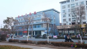 A multi-story building with signage indicating it is a hotel. - Lianyungang Green Apple Hotel Apartment (Lianyungang)