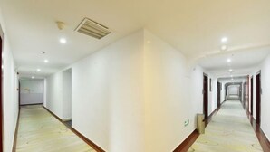 A long, narrow hotel corridor with white walls and a patterned floor. - Yu'an Hotel (Lu'an Guangcai Great Market Railway Station) (Lu'an)