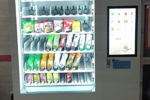 Ein Verkaufsautomat mit verschiedenen Snacks und Getränken.