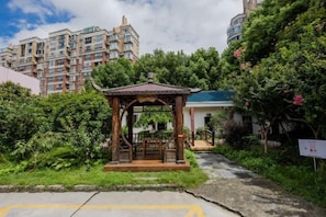 A gazebo in a landscaped area with a building in the background. - Homeinn Hotel (Nanjing South Railway Station Shengtai West Road Cuipingshan Subway Station) (Nanjing)