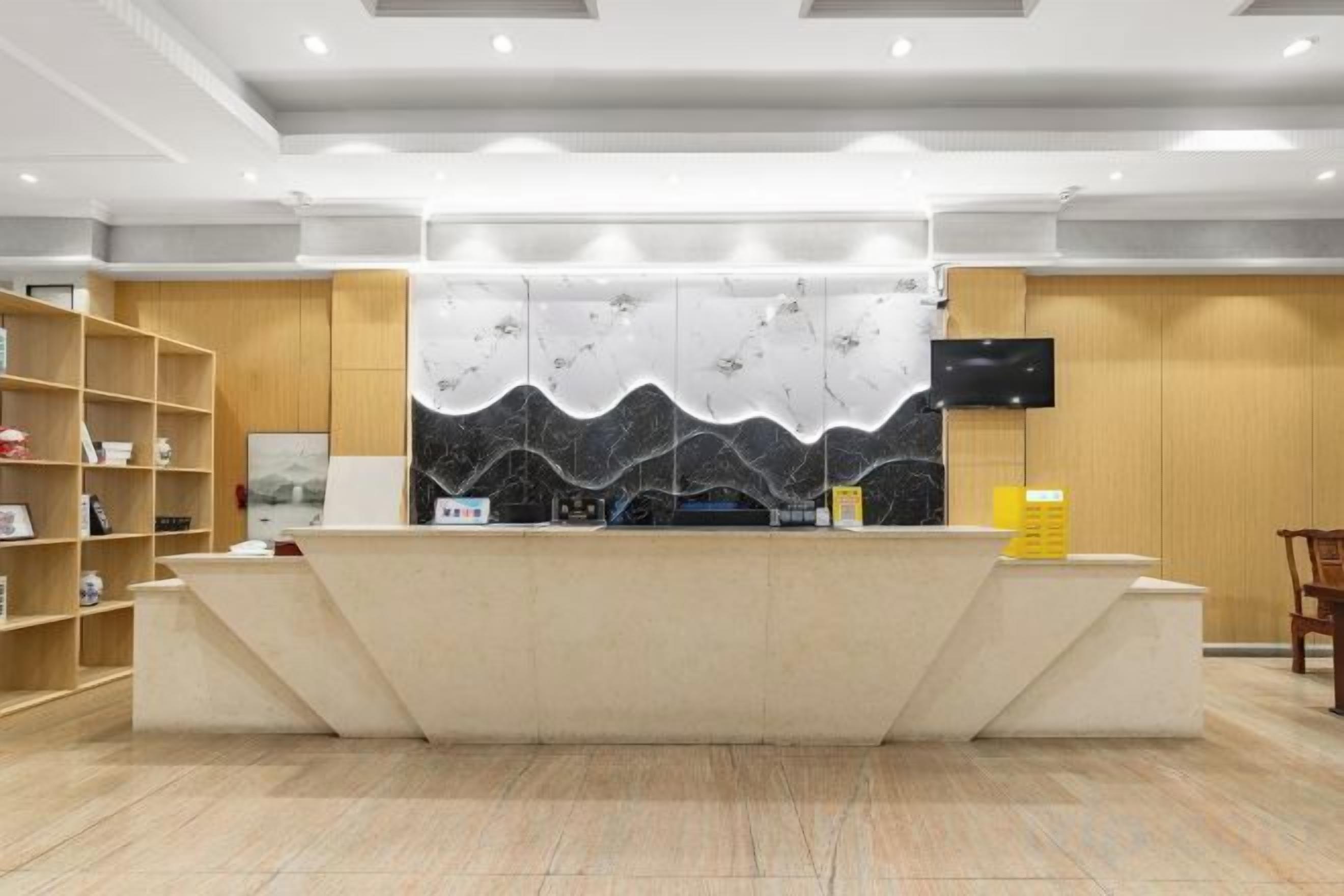 A reception area with a counter, a flat-screen TV, and a wall-mounted TV.