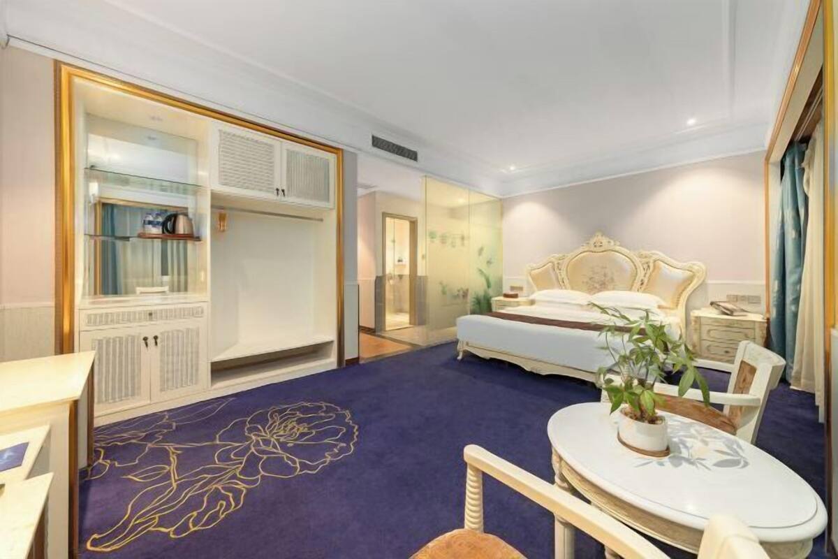 Ein Hotelzimmer mit Bett, Nachttisch, Stuhl und großem Kleiderschrank.