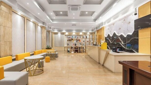 Una hall moderna con zone relax, una reception e una libreria.