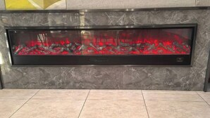 A modern fireplace with a glass front, set in a marble wall. - Homeinn Hotel (Fushun Wanghua Leifeng Memorial Hall) (Fushun)