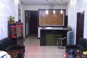 A hotel lobby with a reception desk, a fish tank, a large painting, and a reception counter. - Gaochun Tianhao Hotel (Gaoyi)