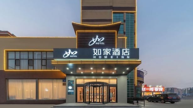A hotel with a modern facade, featuring a prominent sign with the name "Homeinn Hotel". - Home Inn (Linyi Luozhuang District Government) (Linyi)