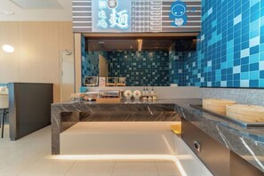 A modern reception area with a marble counter, a blue-tiled wall, and a neon sign. - Home Inn (Linyi Luozhuang District Government) (Linyi)