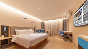 A modern hotel room with a large bed, a desk, a chair, and a TV mounted on the wall. - Home Inn (Linyi Luozhuang District Government) (Linyi)