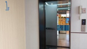 A hotel entrance with a glass door, a wall-mounted phone, and a digital display. - Home Inn (Linyi Luozhuang District Government) (Linyi)