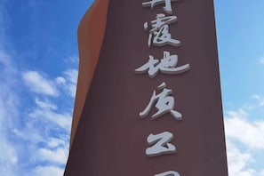 A vertical sign with white text on a dark background.