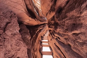 Eine schmale Schlucht mit einer Holzleiter, die nach unten führt.