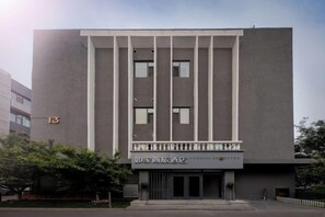 A modern building with a flat facade, a balcony with railings, and a sign indicating it is a hotel. - Homeinn Selected Hotel (Beijing Beihai Park Peking University Hospital) (Beijing)