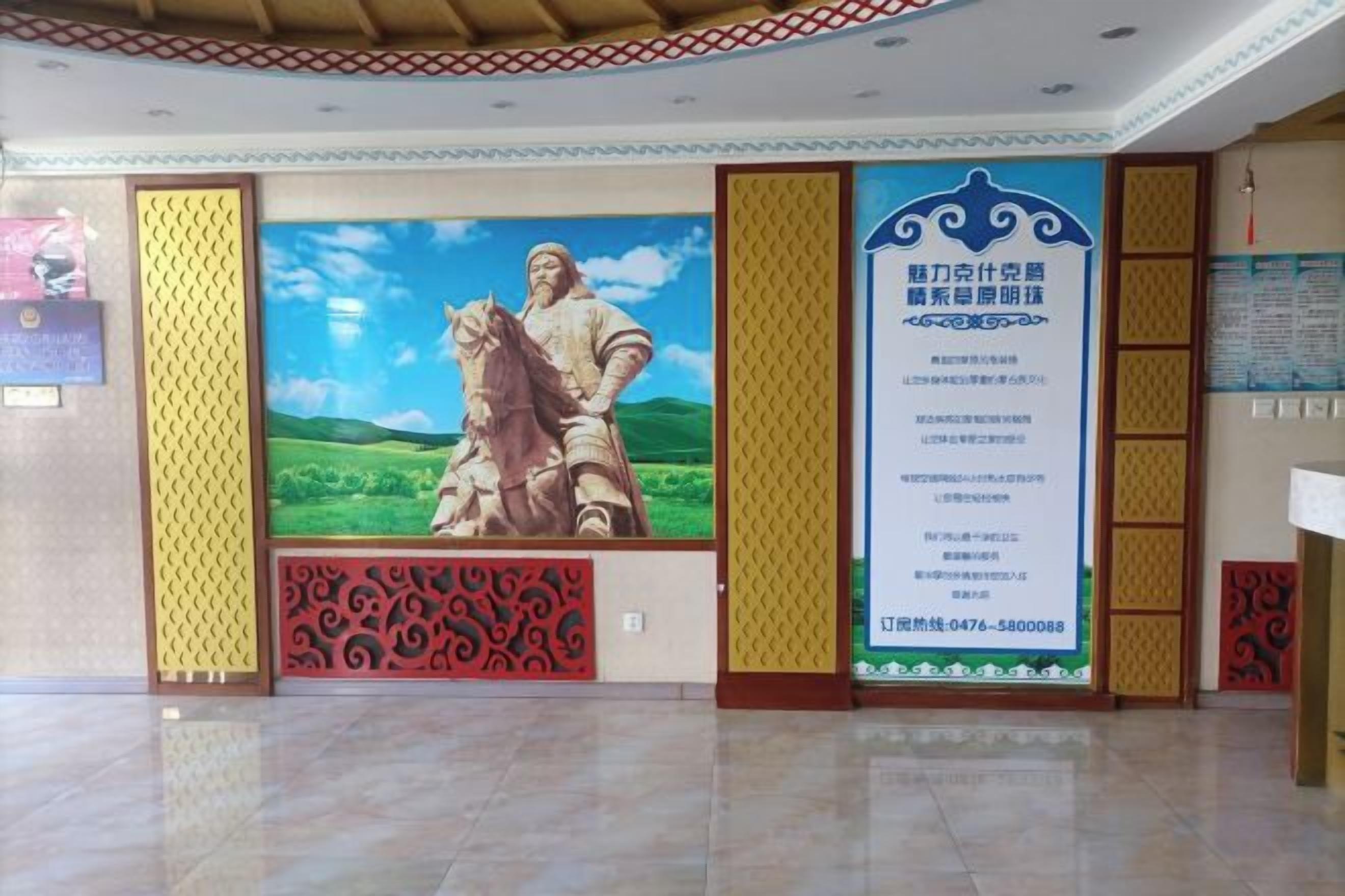 Un vestíbulo con un mural grande, una mesa de recepción y un diseño de pared con motivos.