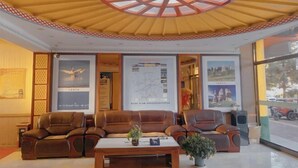 A lobby with leather sofas, a wooden coffee table, and a large map on the wall. - Prairie Pearl Express Hotel (Hexigten Banner)