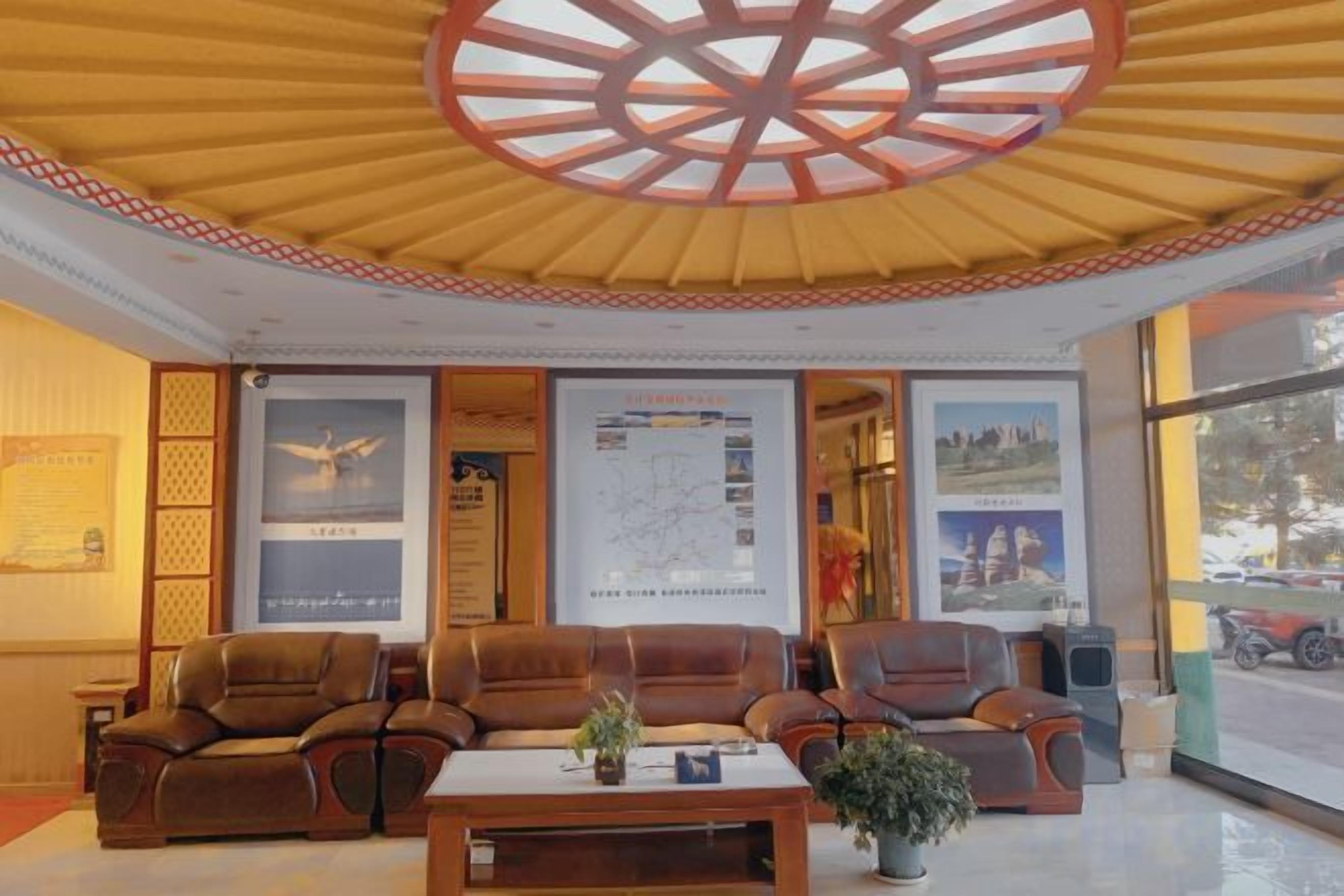 A lobby with seating, a central table, and a large window.
