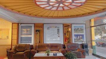 A lobby with seating, a central table, and a large window.