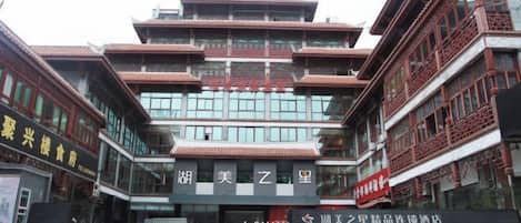 Un edificio tradicional de varios pisos con una entrada destacada y señalización.