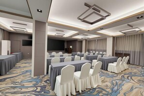 A conference room with tables and chairs, a large screen, and a carpeted floor. - LAKE STAR Designer Curated Hotel (Quanzhou Ancient City Food Street) (Quanzhou)
