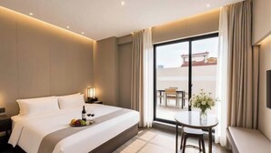 Una habitación de hotel con una cama grande, una mesita con un florero y un balcón con vistas.