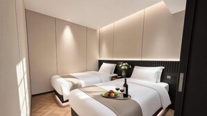 Una habitación de hotel moderna con una cama grande, mesitas de noche y un pequeño escritorio.