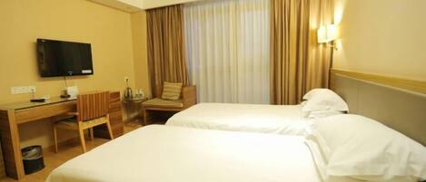 A hotel room with two beds, a desk with a chair, a television, and a window with curtains.